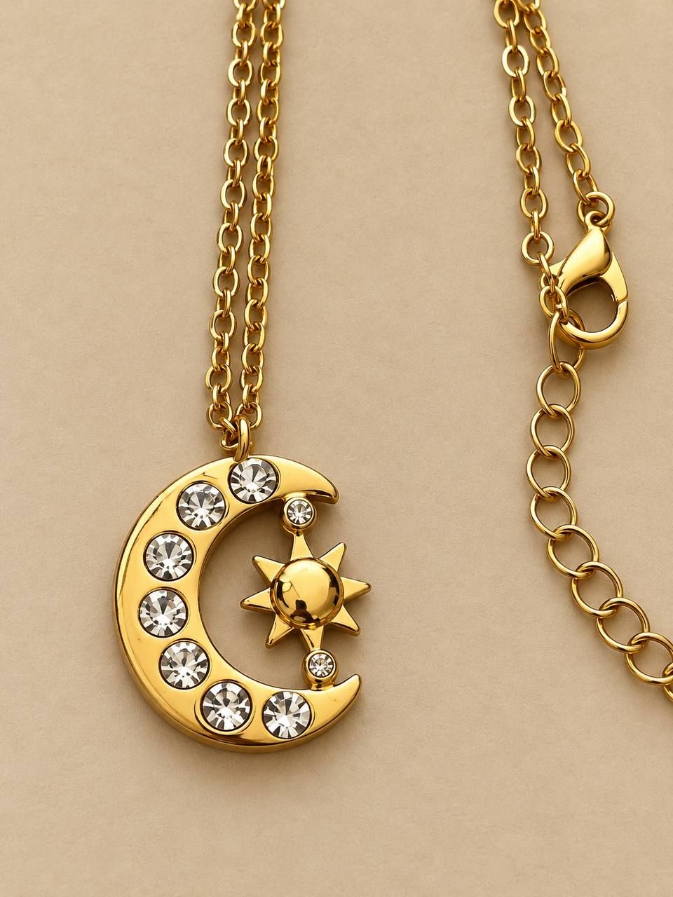 Gold-colored necklace with a moon-and-sun pendant featuring white crystals 3