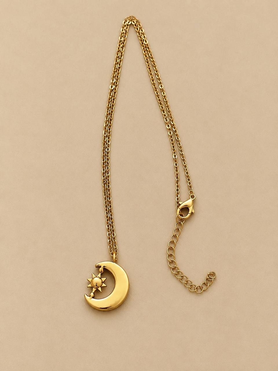 Gold-colored necklace with a moon-and-sun pendant featuring white crystals 2